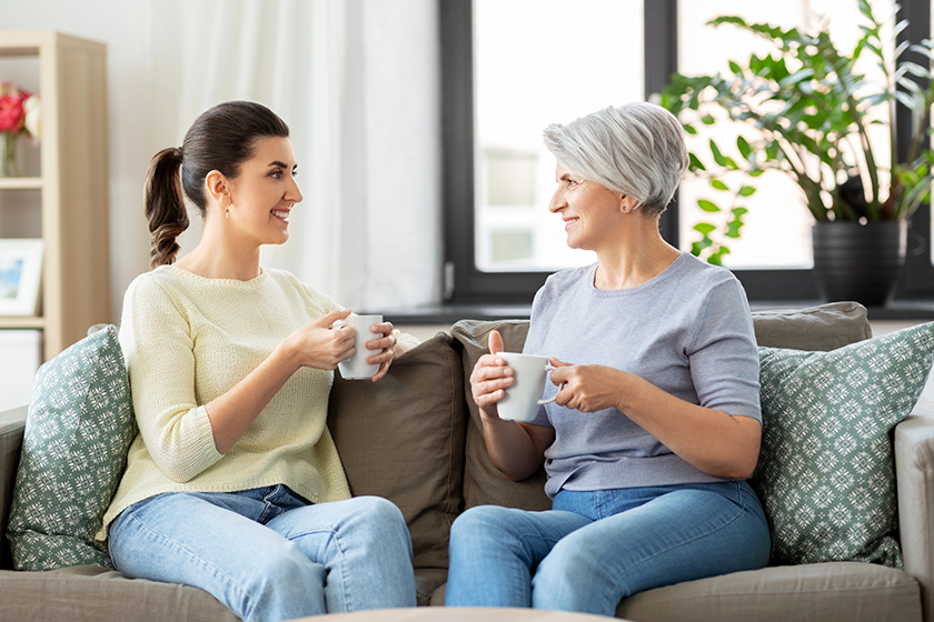 Senior mother and adult daughter drinking coffee 