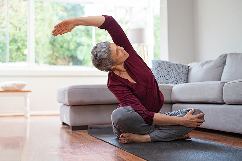 Senior woman exercising while sitting in lotus position