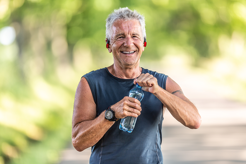 smiling-fit-retired-man-grey-hair-smiles-opens-bottle